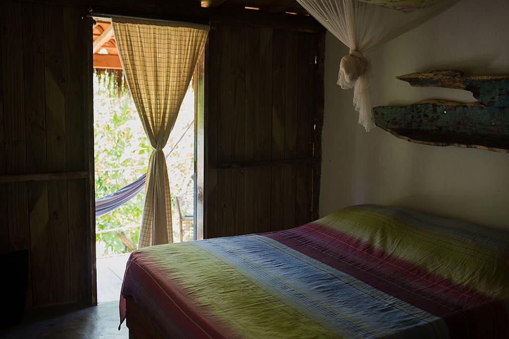 Quarto com cama de casal e banheiro privativo.