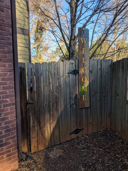 Private gate to entrance. Handmade welcome sign made from repurposed fence posts.