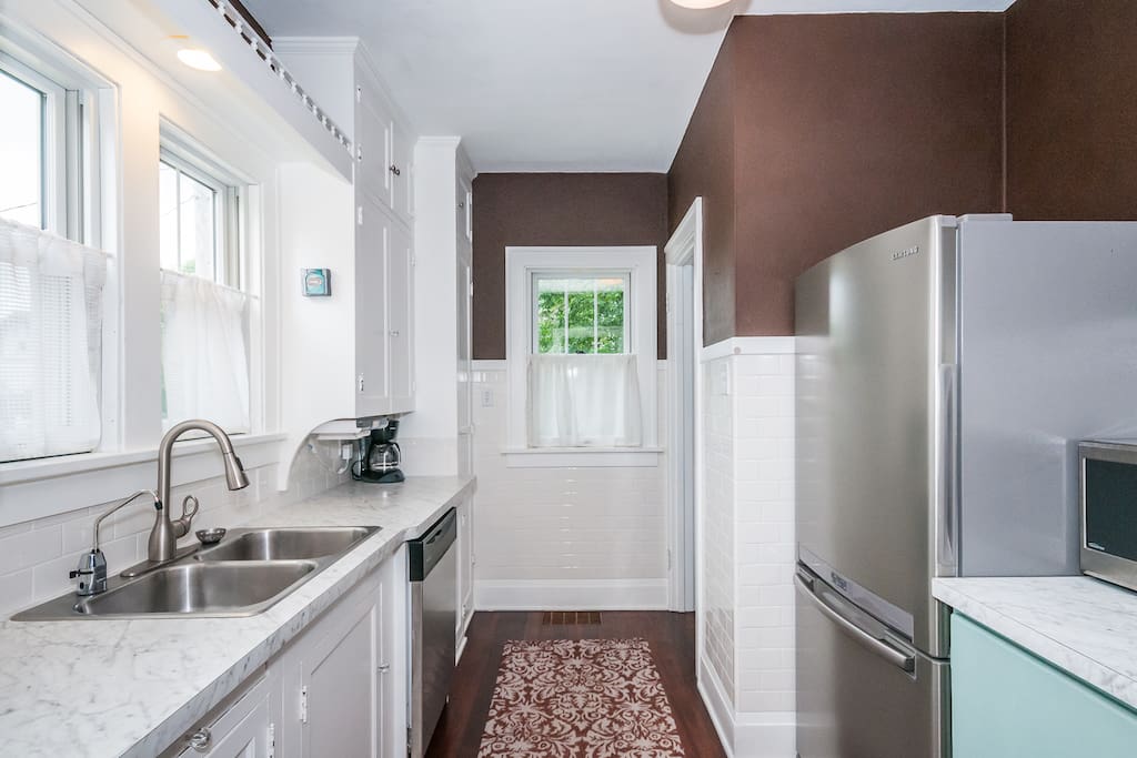 Main floor: Kitchen is equipped with refrigerator, stove, microwave, dishwasher, and coffee maker.