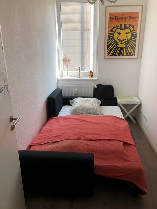 Dein Zimmer mit großem Fenster zum Hinterhof und gemütlicher Schlafcouch