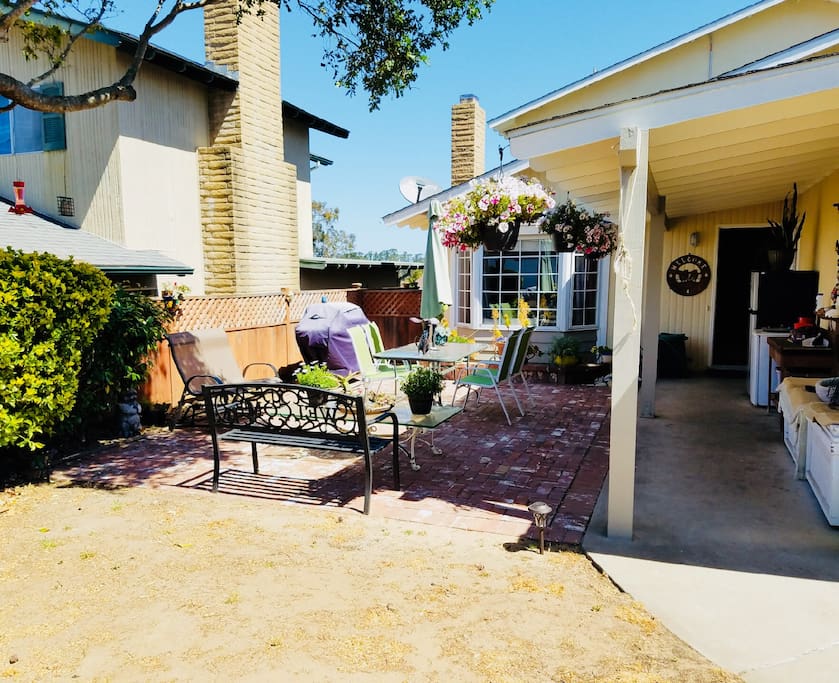 Outside patio with dining tables and grill