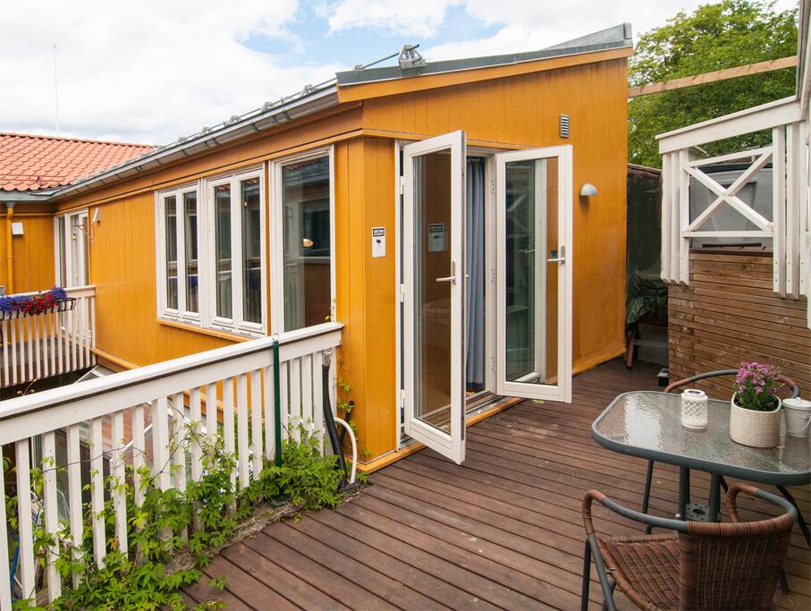 Terasse med bord og stoler. / Terrace with table and chairs