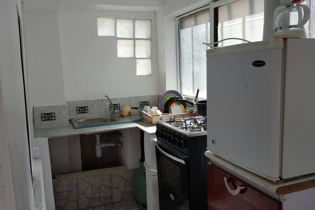 Cuisine séparée, équipée de frigo, de cuisinière 4 feux avec four, d ustensiles de cuisine