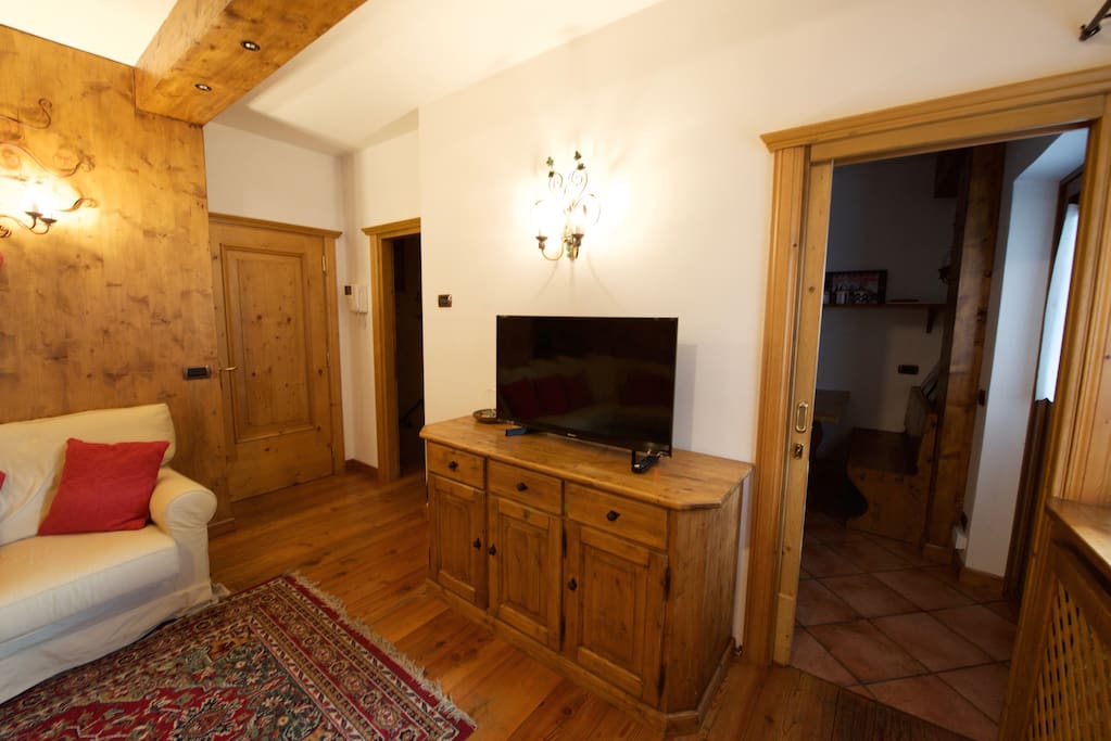 Il salotto e la TV a schermo piatto. Porta d'accesso alla cucina