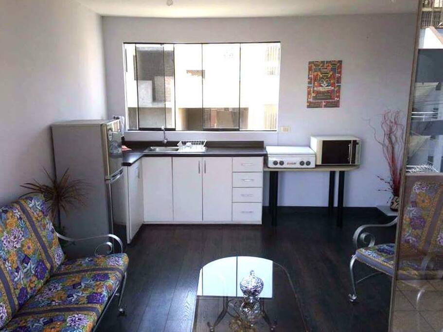 Cocina totalmente acondicionada con refrigerador, microondas, cocina, vajilla, cubiertos y utensilios necesarios