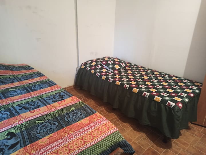 Chumba cha 2 kilicho na vitanda viwili na sakafu ya usaidizi, magodoro ya mifupa yaliyo na kinga ya godoro, yenye mashuka rahisi,mito na feni za dari na meza.