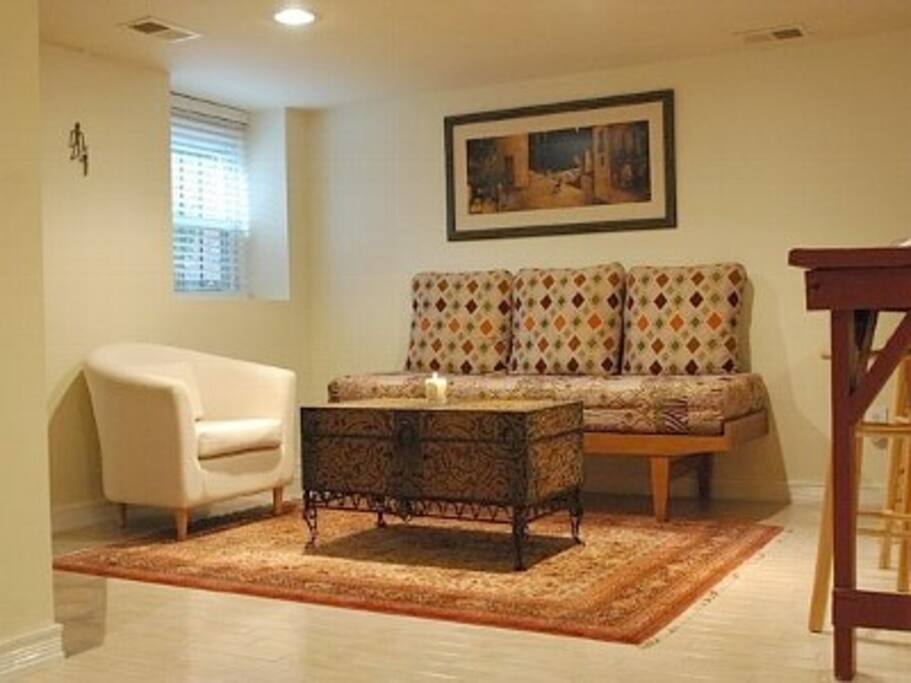 Living room area with couch that converts to a twin bed.