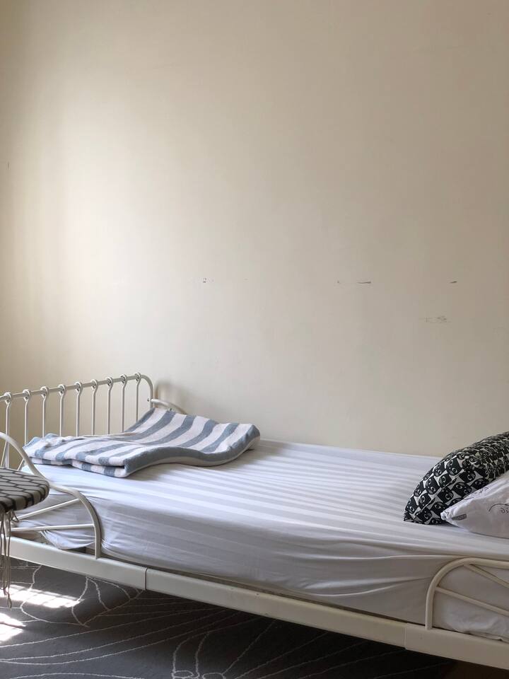 Chambre juste équipée d'un lit simple, d'un ventilateur de plafond et d'un support de miroir. Un fer à repasser avec planche et support pour suspendre votre robe a également été fourni.