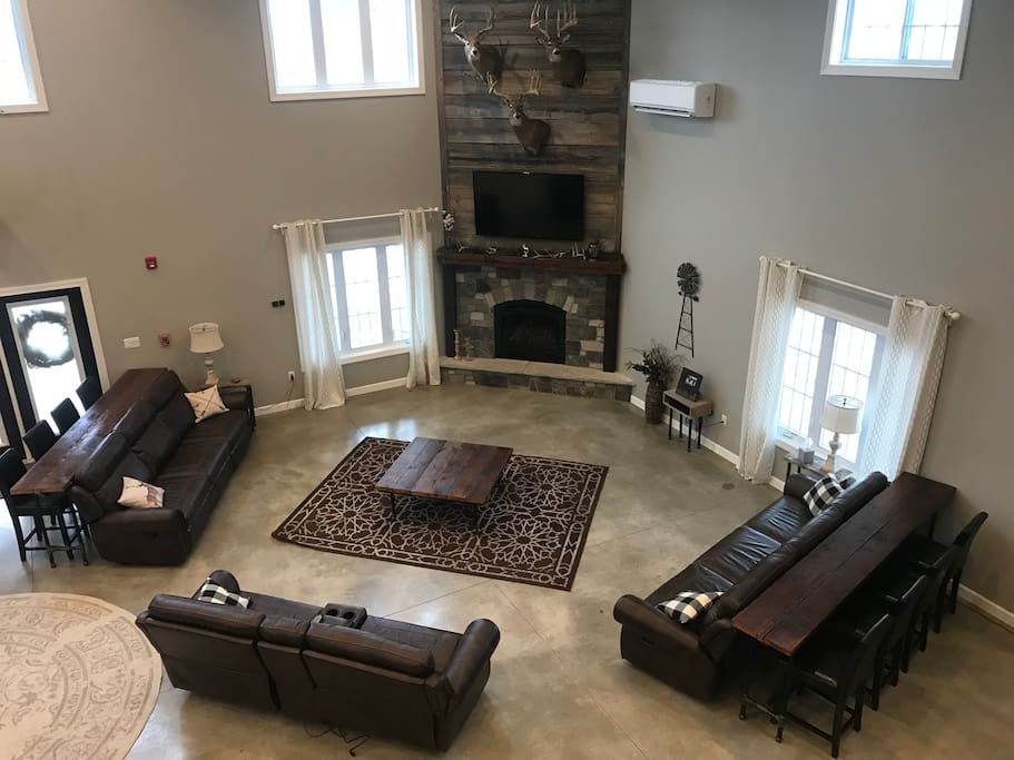 Great Room living area with gas fireplace, satellite TV and seating for 8 at couch tables.