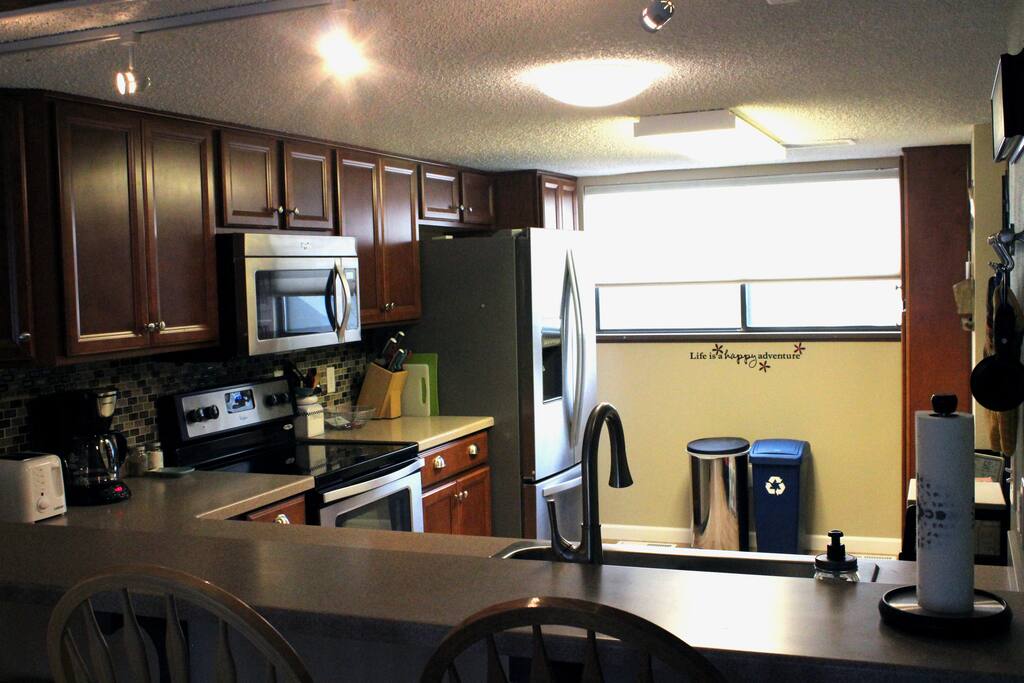 Totally modern kitchen with a bar for eating with 4 stools.