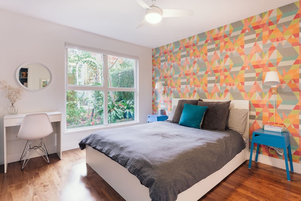 Primary bedroom featuring queen size bed, private garden views and ensuite bathroom