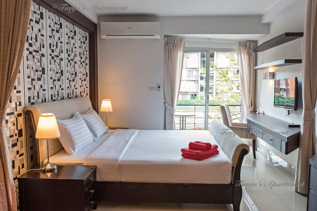 Bedroom with large double bed and balcony on the pool