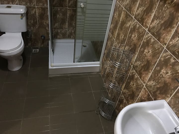 This is a bathroom attached to bedroom 2 on the first floor. The bathroom is measuring 9ft by 6 ft while the bedroom is measuring 19ft by 17 ft. The bedroom has a tv, Aircondition, dressing mirror , bed, waldrope and chair.m