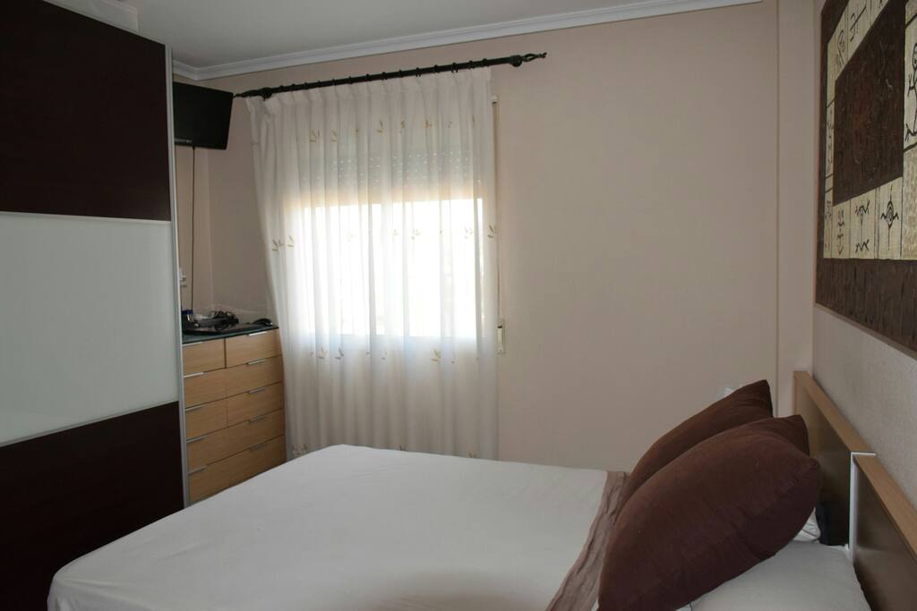 Habitacion principal con cama de matrimonio y armario amplio.