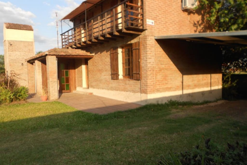 exterior de la casa. La casa tiene balcón, y detrás de la separación en el porche se encuentra la otra casa que conforma el complejo