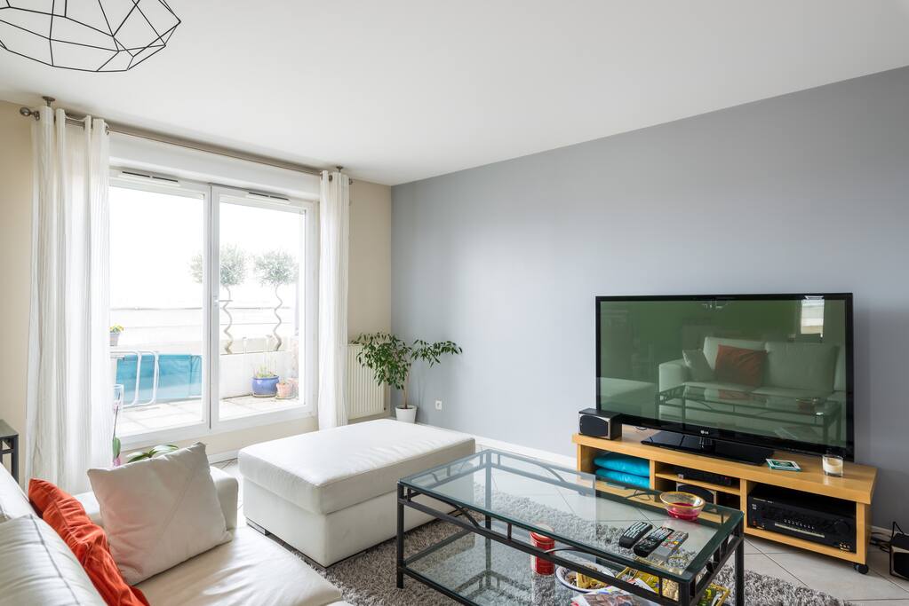 salon avec canapé en cuir et grande télé