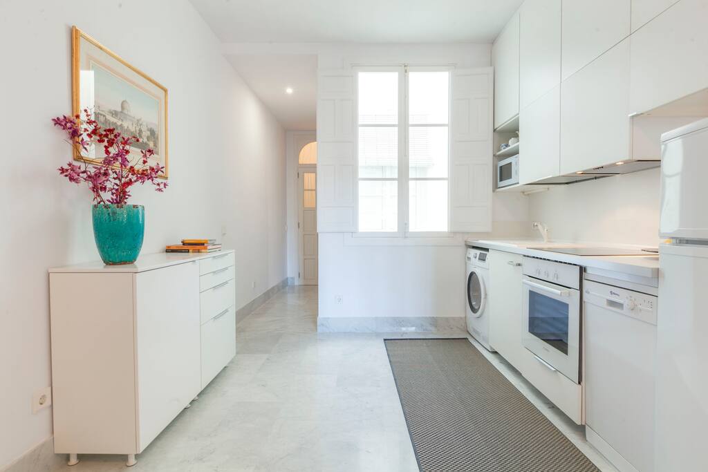 The open-concept kitchen is equipped with fridge-freezer, ceramic hob, oven, microwave, dishwasher and a washer-dryer.