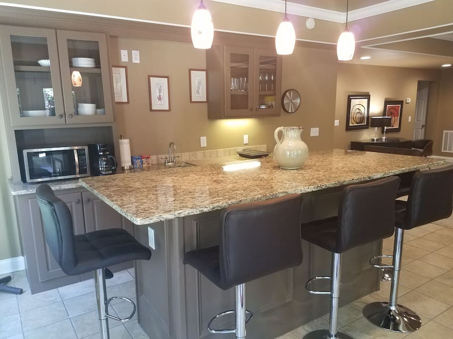 "Bar kitchen" - Five bar stools around a stunning, one-piece granite countertop.