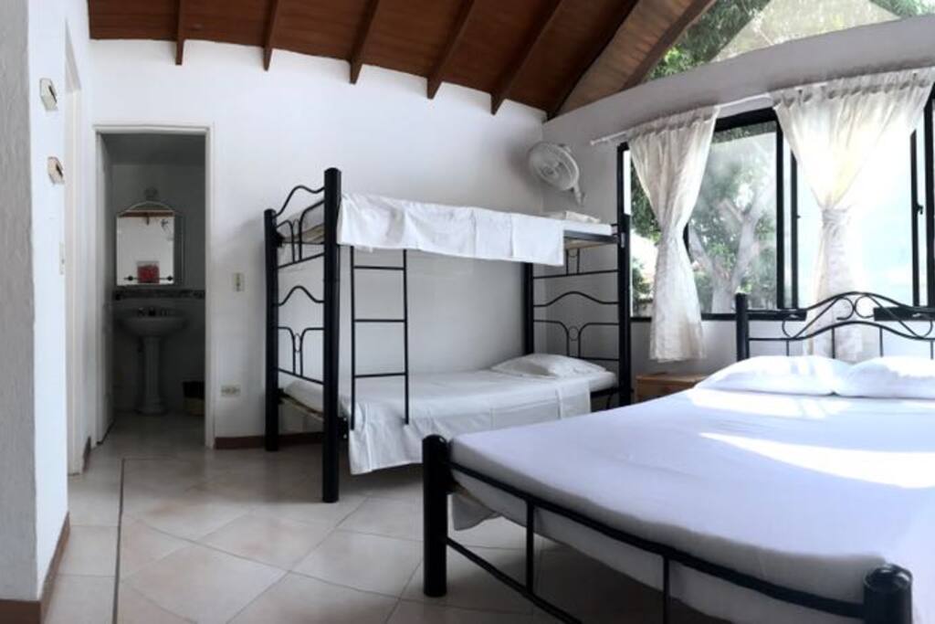 Large bedroom with a double bed and a bunk bed. All rooms have a private bathroom.
Alcoba grande con camarotes, cama doble y baño privado