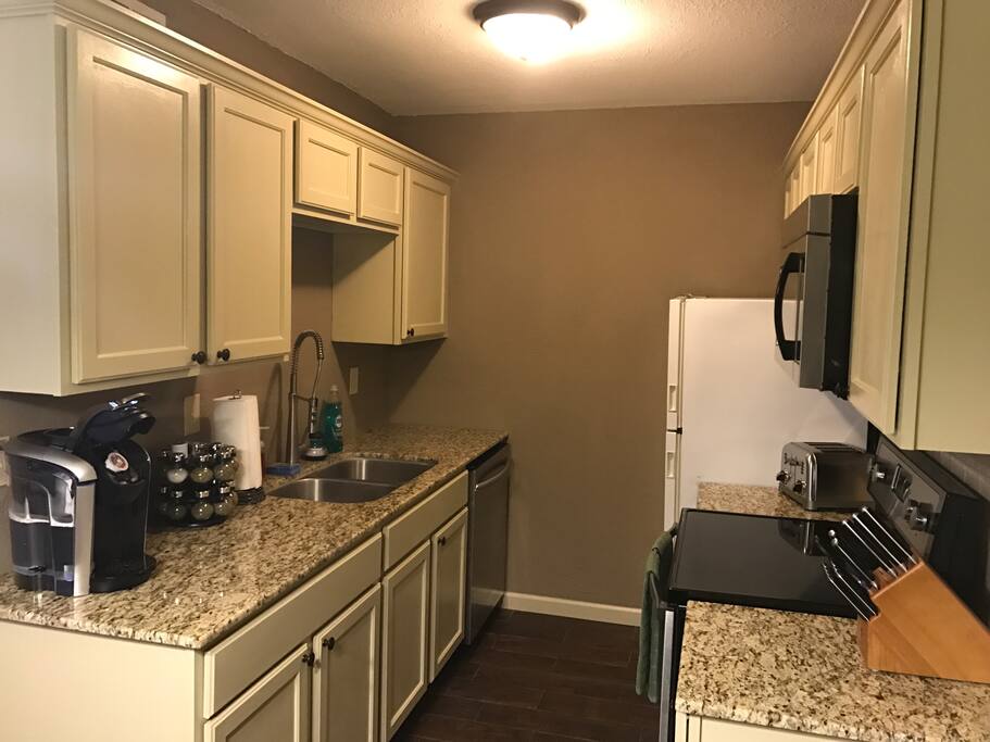 Kitchen - with a Kuerig. Kitchen is stocked with plates, glasses, utensils and cookware (pots and pans).
