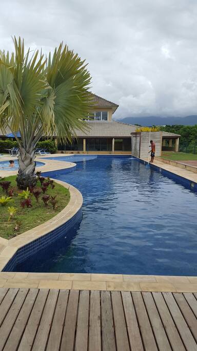 Piscina com prédio da academia ao fundo.