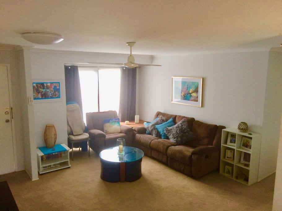 Lounge room with 3 recliners massage chair, entertainment unit and aircon.