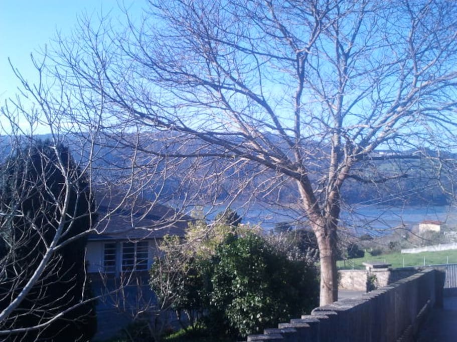Parking by the road, apartments door and estuary at high tide.