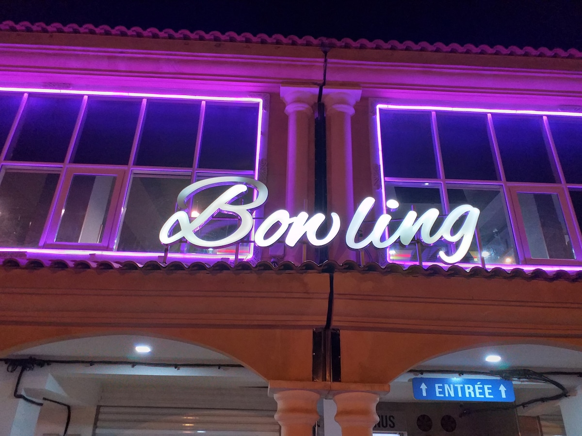 The exterior of a building is displayed at night, illuminated with vibrant pink lighting. The sign reading 'Bonling' is prominently featured, surrounded by large windows revealing a modern interior. Architectural details, such as columns, enhance the overall aesthetic.