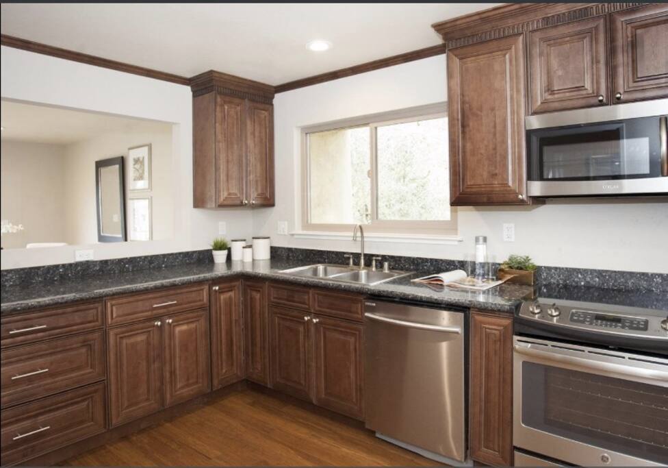 Large kitchen with microwave, electric stove, oven, dishwasher and refrigerator.