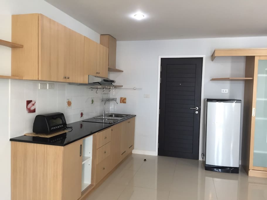 Kitchen is fully equipped with stove, fridge, and small over.