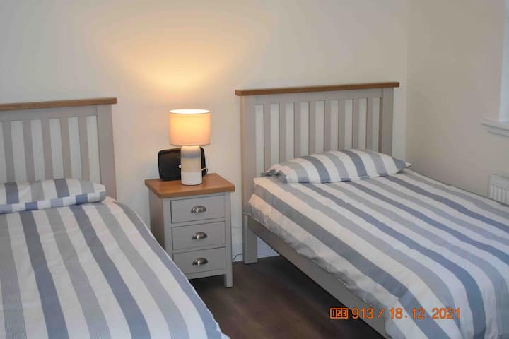 La habitación con dos camas individuales y armario