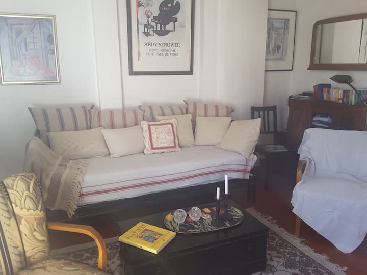 Sala de estar en el tercer piso  con sofá cama grande y terraza.
