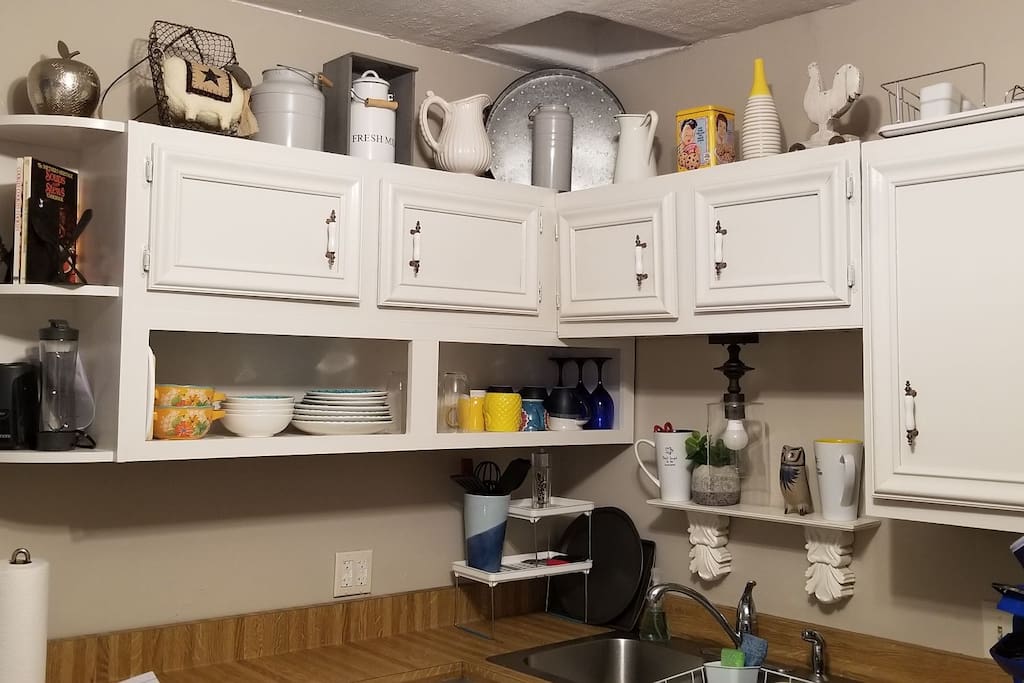 toaster, coffee maker, open shelving in kitchen with glasses, dishes etc