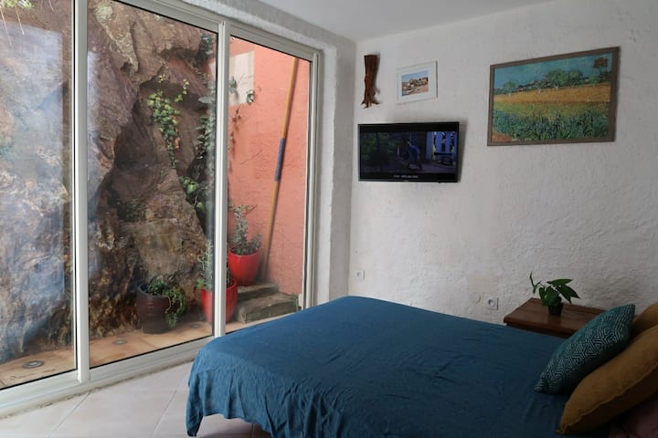 Спална соба бр. 4 со брачен кревет (160 см), клима уред, тавански вентилатор, паметен телевизор и големи прозорци со прекрасен поглед на карпата и градината.