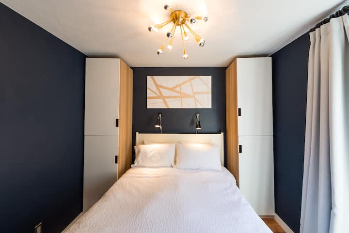 Petite bedroom with ample storage, queen sized Serta memory foam mattress, down alternative comforter, Egyptian- cotton high thread-count sheets, and custom paintings and light fixtures.