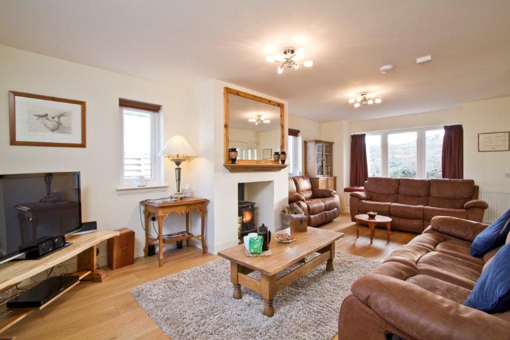 Spacious living room with flat screen television, unlimited WI-FI and wood burning stove