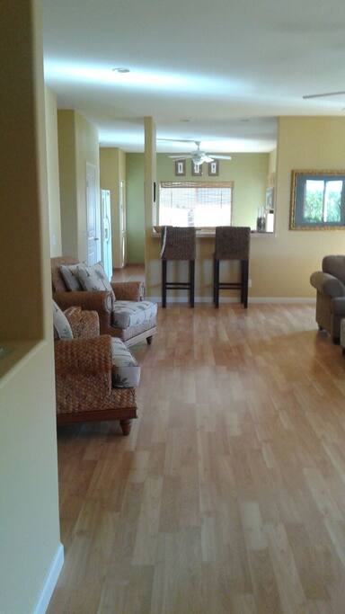 Broad view of great room with bar seating at kitchen entrance
