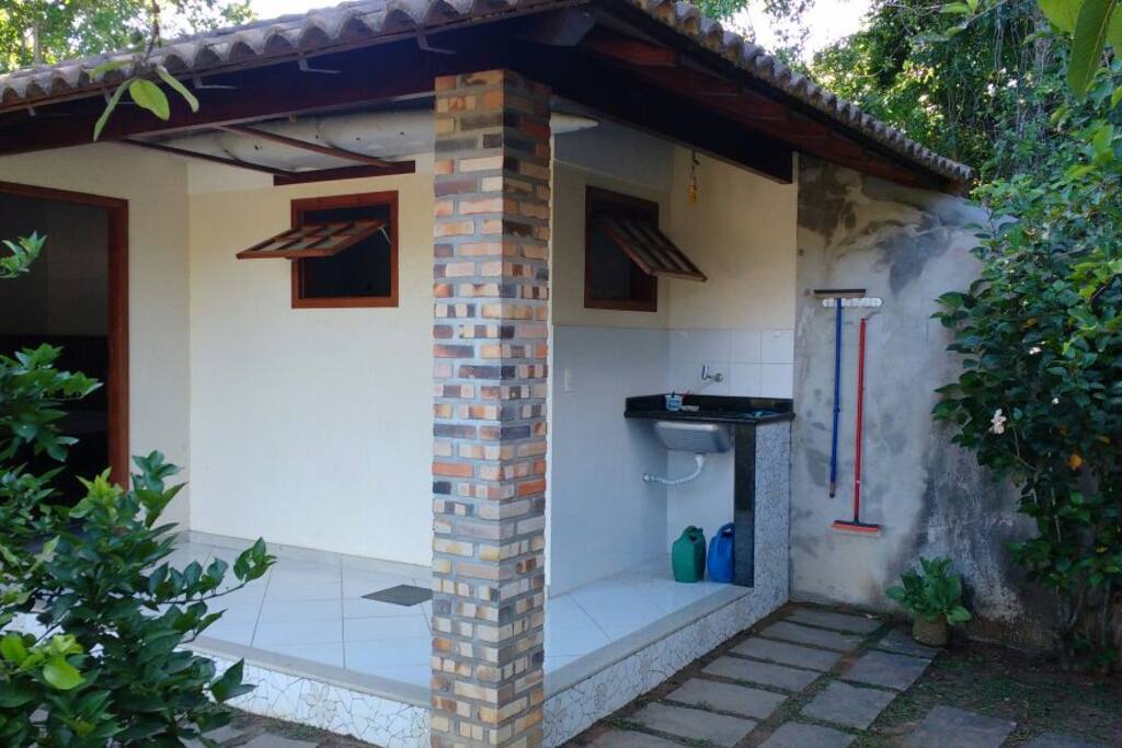 Lateral da casa com tanque e varal de roupas