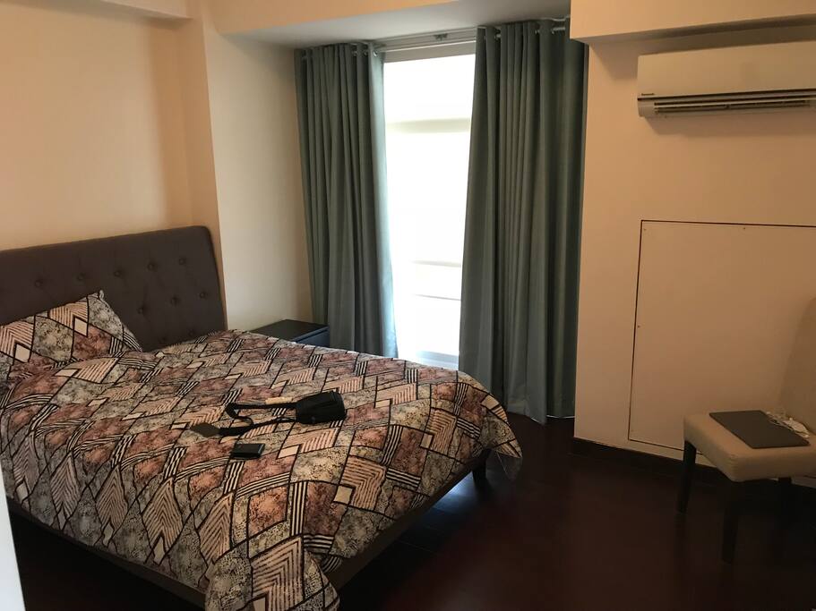 1st bedroom with polished wooden floors and cupboard