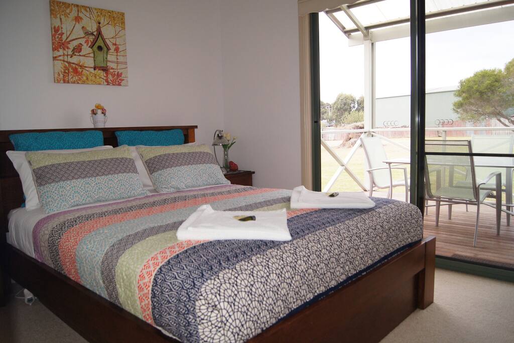 Bedroom with queen size bed, comfortable bed, sliding door to decking and sealing fan