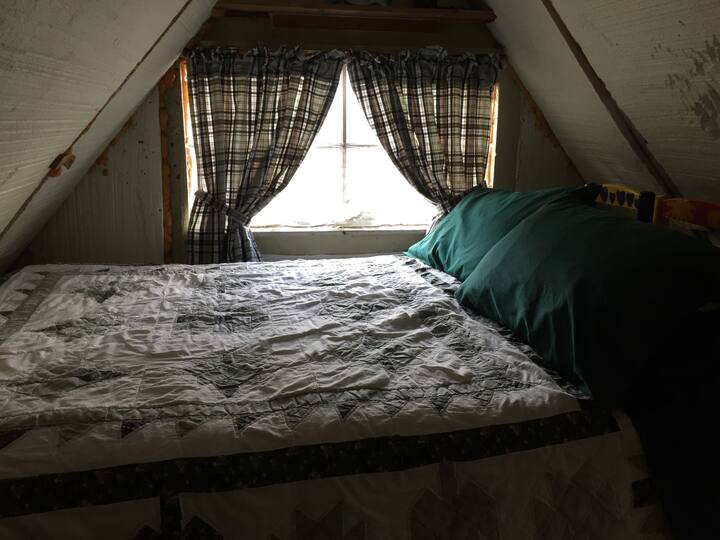 A double bed is tucked under the eves at the top of the stairs. Bear claw marks on the ceiling are from a long-ago accidental visit.