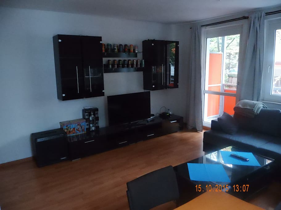 Große Wohnwand samt 45" Smart-TV und Zugang zum Balkon