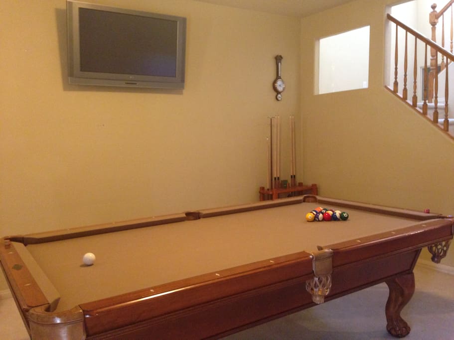 The pool table located in the entrance. It also comes with a mounted TV so you can stream from your phone to the TV while playing pool!