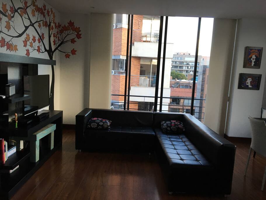 The apartment living room with TV and balcony.