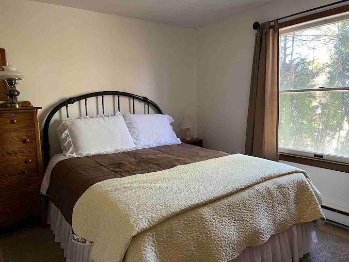 Main bedroom has a queen bed and a cozy chair to snuggle up in and read a book.