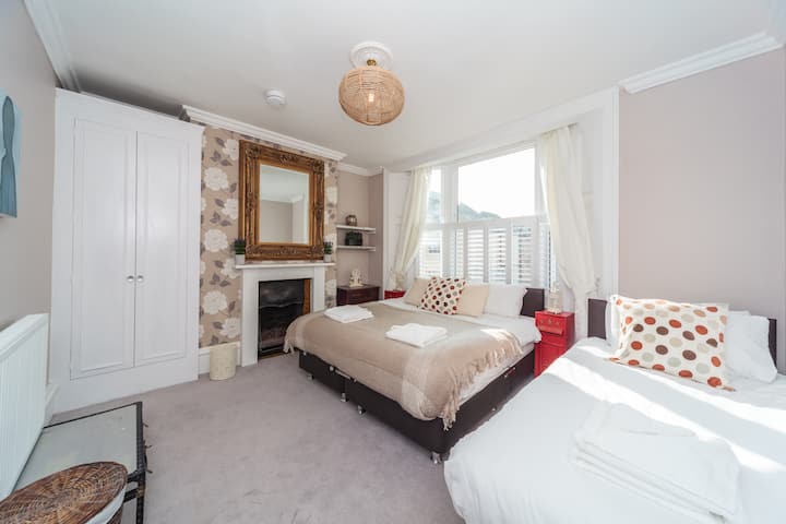 Първата спалня на етаж с капаци и завеси . Може да са три единични или единични и единични. 