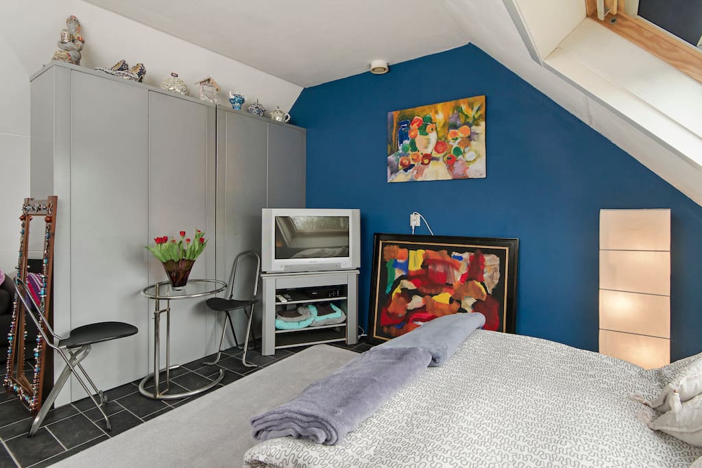 Guestroom all over vieuw, tv and breakfast table and chairs