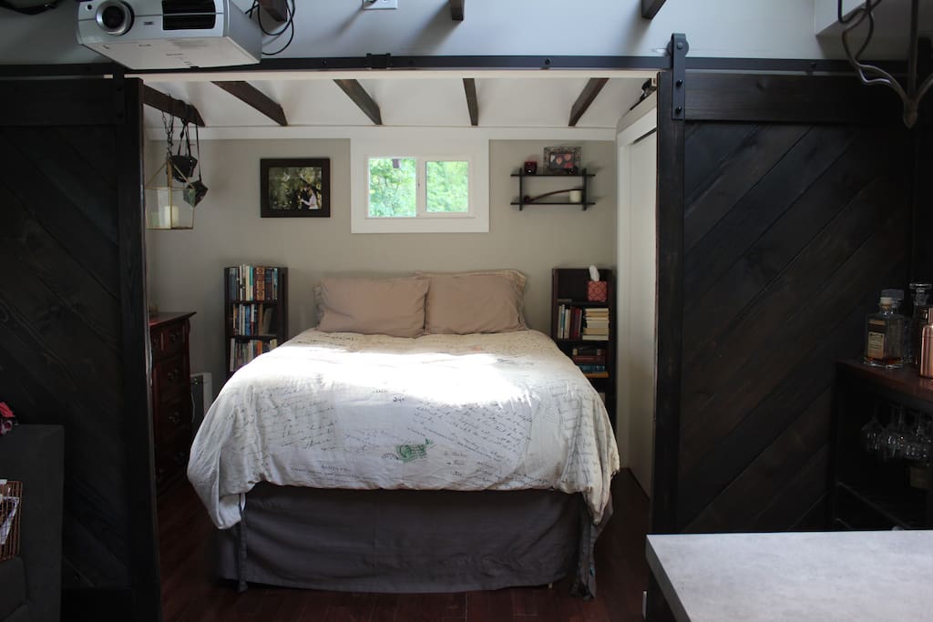 Behind sliding barn doors is the comfortable queen bed, with lofted ceilings and a designer fan.