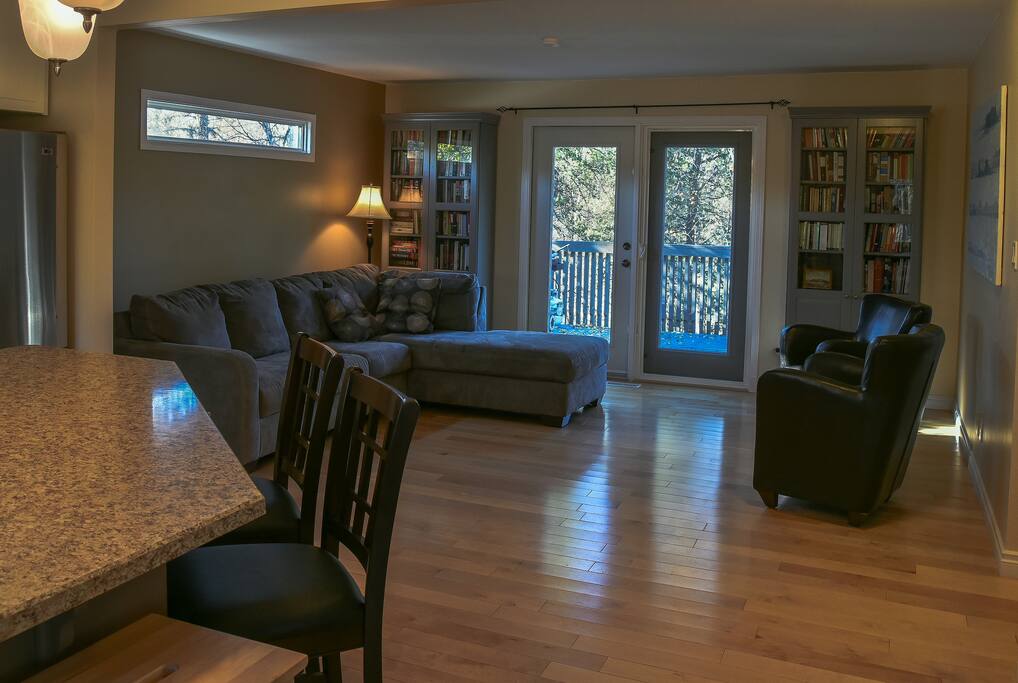 Greenery is visible out of every window. A roomy deck overlooks the tree-filled backyard.