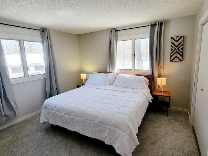 ห้องนอนนี้อยู่ชั้นบนมีเตียงขนาดคิงไซส์ยิงเฉดสีเข้มของห้องสมาร์ททีวีและรีโมท Roku